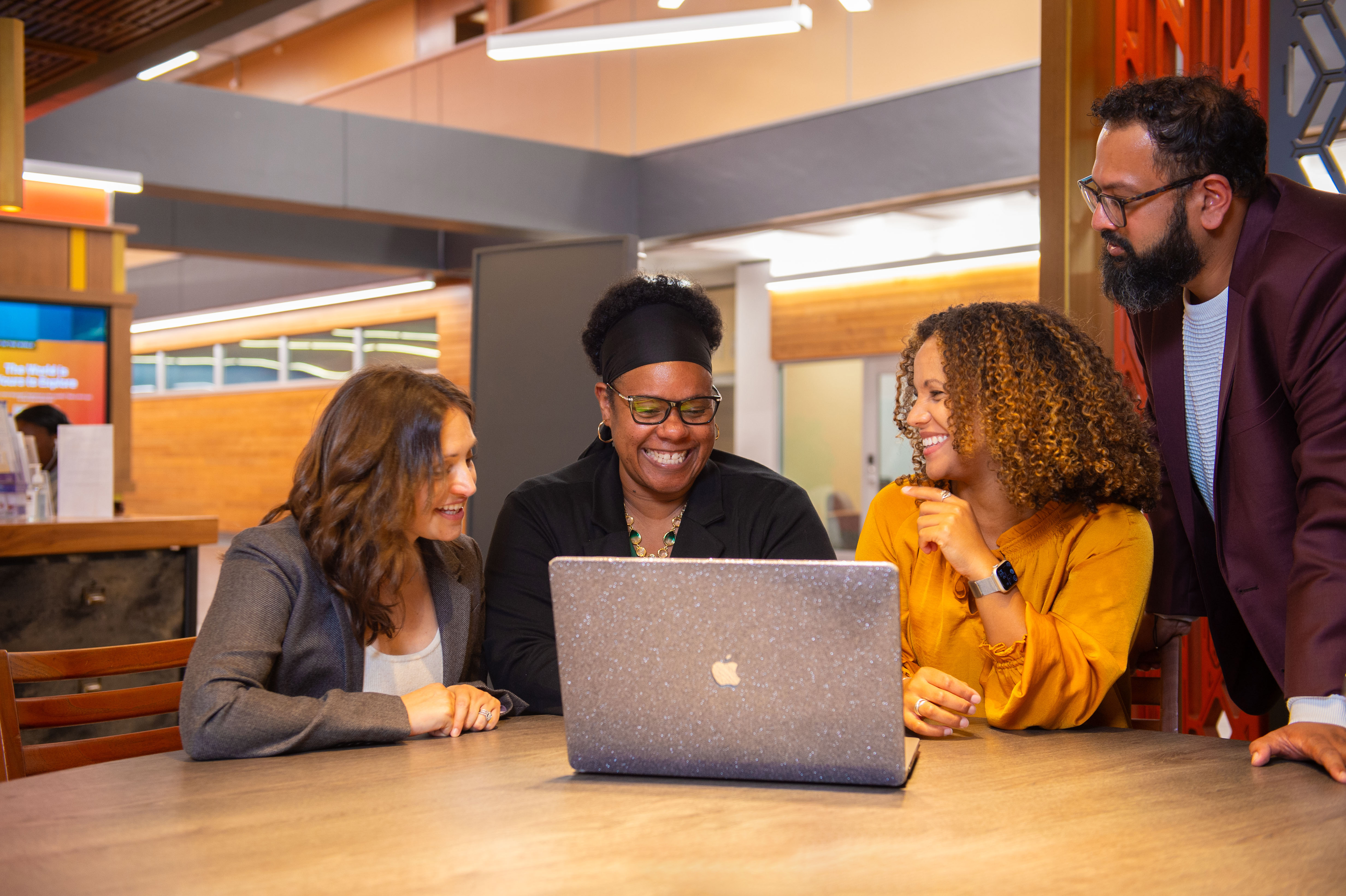 CuPID group smiling while working around a laptop